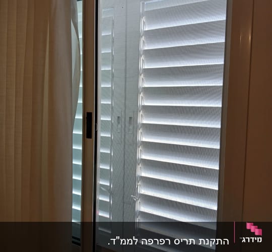 חלון אלומיניום עם תריסים סגורים ורשת